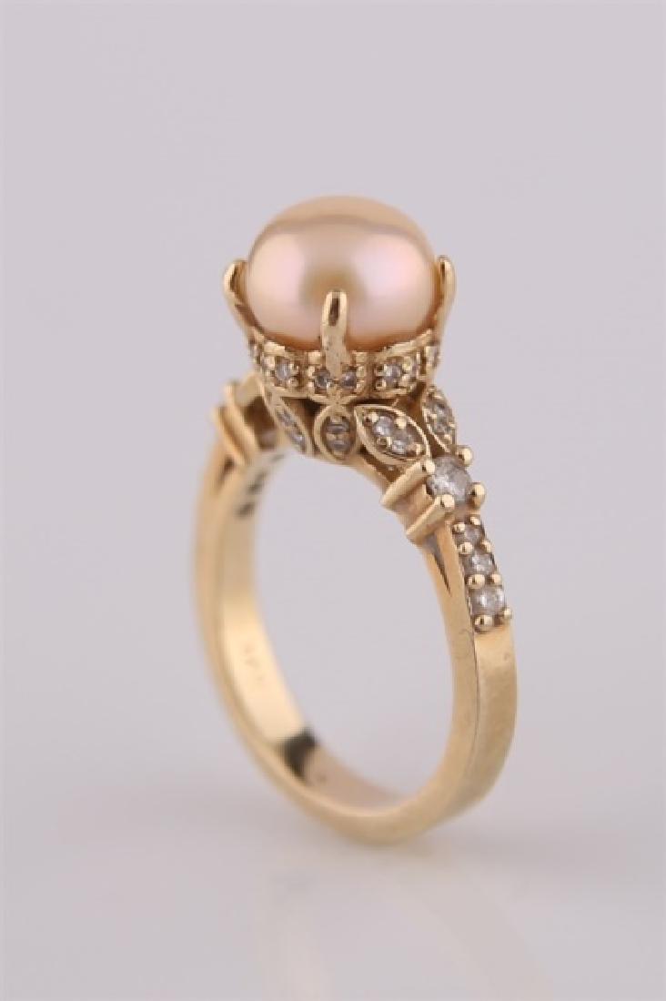 14kt Yellow Gold and Pearl Ring: 14kt yellow gold ring with pearl centerpiece. Pearl flanked by several colorless small pieces of moissanite. Interior of band marked "14K". Size: 6 1/2. Weight: 6.3 g.