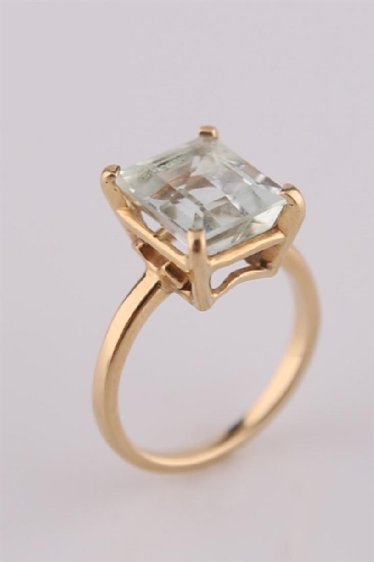 14kt Yellow Gold Aquamarine Stone Ring: 14kt yellow gold ring with large square cut aquamarine stone. Interior of band marked "14K" with maker's mark stamp. Size: 5 1/4. Weight: 3.6 g.