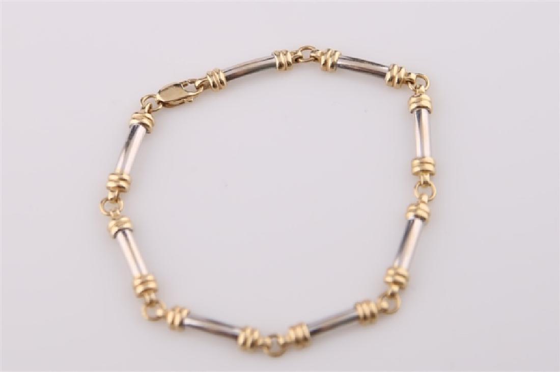 14kt Yellow and White Gold Bracelet: 14kt yellow and white gold bracelet. Segmented chain design. Length: 7 1/4". Weight: 7.4 g.