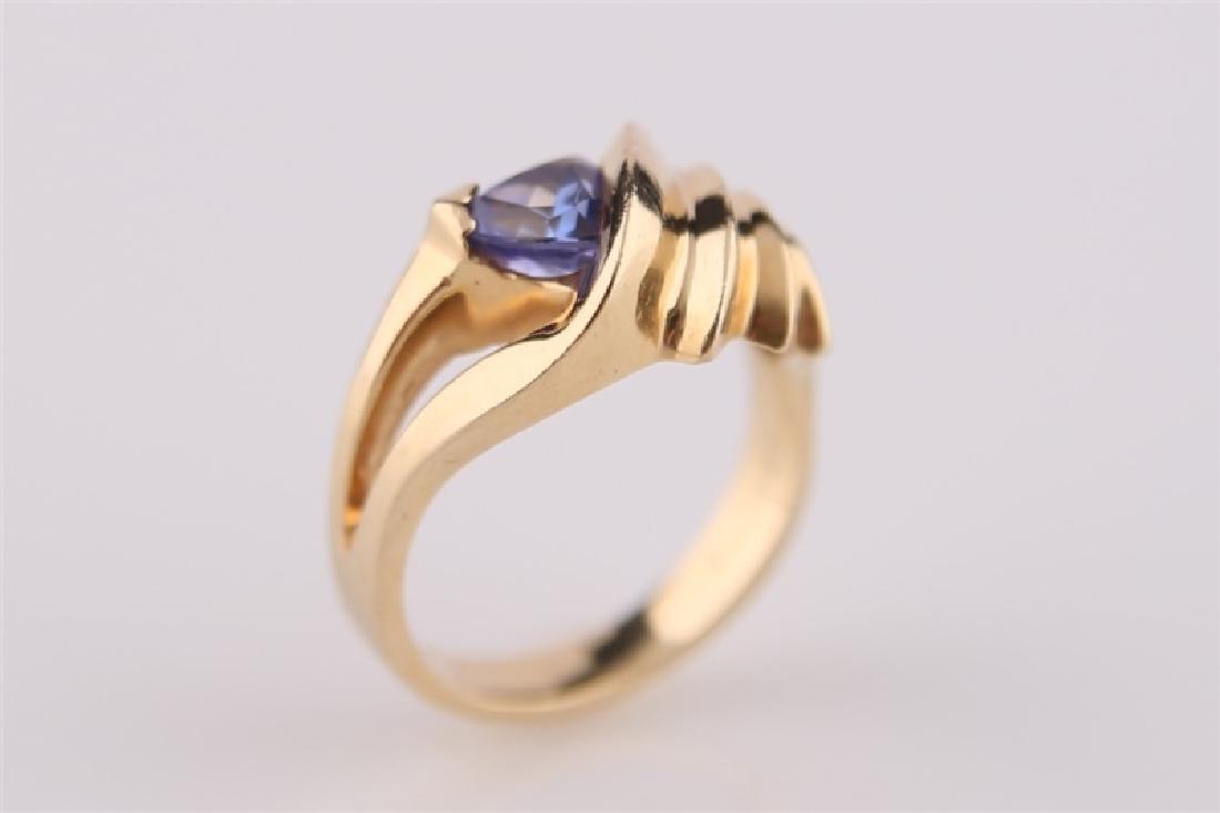 14kt P Yellow Gold Ring with Tanzanite: Ring marked "14kt P" yellow gold with tanzanite. Interior band marked "C.L. Designs". Size: 7. Weight: 8 g.