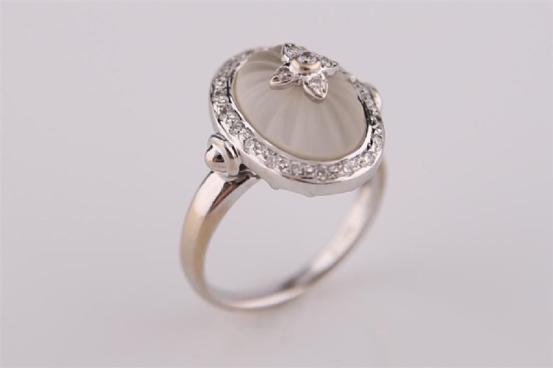 18kt White Gold, Diamond, and Carved Quartz Ring: 18kt white gold ring with carved crystal quartz and diamonds. Twenty-five (25) diamonds totaling approx. .20 cts. Band marked "750 18kt". Size: 6 1/4. Weight: 7.3 g.