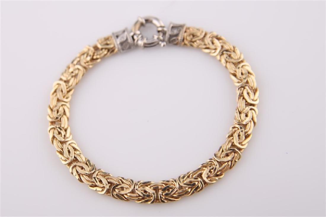 14kt Yellow Gold Chain Bracelet: 14kt yellow gold two-tone chain bracelet. Two diamond chips. Flat Byzantine-style bracelet. Clasp marked "MA 14K". Length: 7 1/4". Weight: 9.2 g.