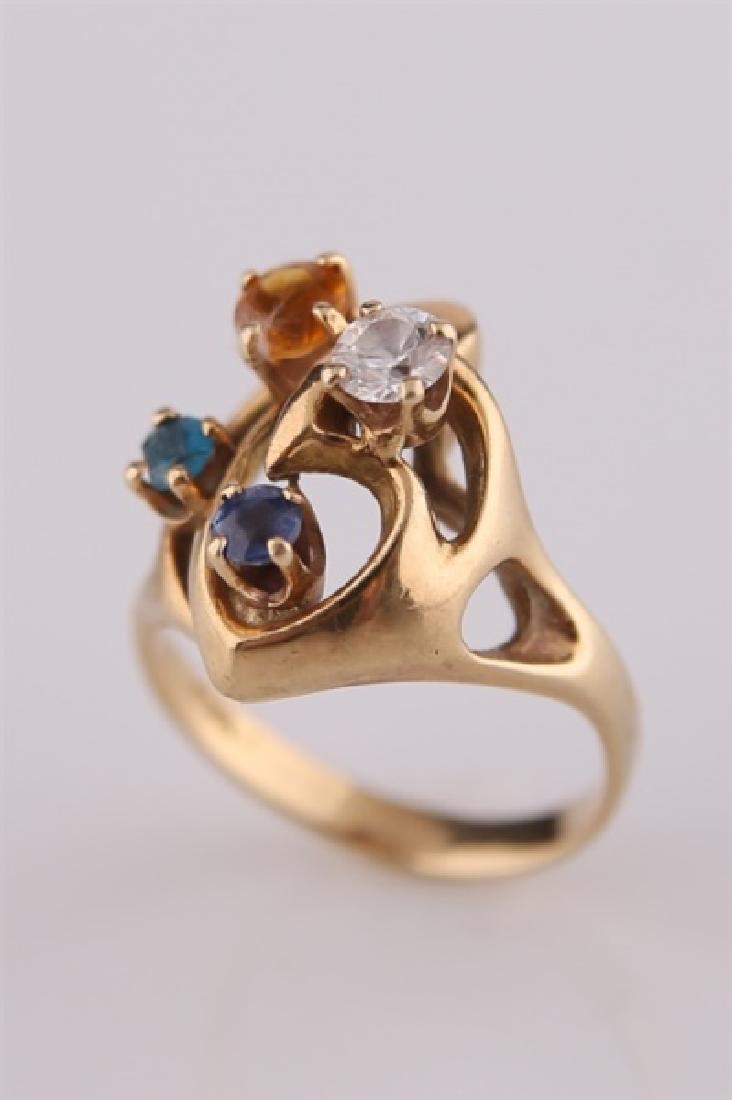 14kt Yellow Gold Mothers Ring: 14kt yellow gold ring with multicolored stones. Orange, green, purple, and colorless stones, referred to as, Mother's Ring. Interior band marked "14K". Size: 5 3/4. Weight: 5 g.