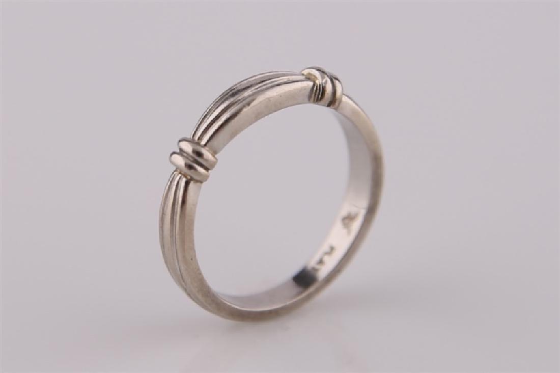 Platinum Ring Band: Platinum ring band with ridged design. Marked "Plat." to interior of band and with maker's mark. Size: 6. Weight: 5.4 g.