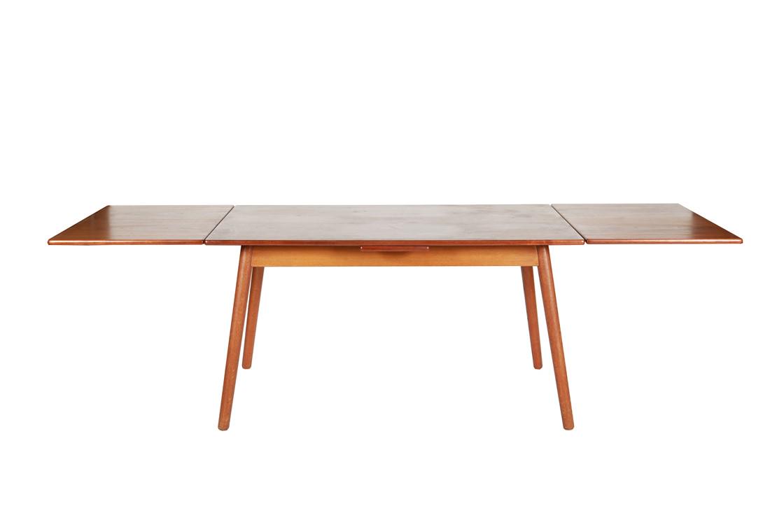 Danish Teak Draw Leaf Dining Table: Dining table. Teak. c. mid-20th century. Height: 28 1/4", Width: 33 3/4", Length: 53", Length (Extended): 96 1/4". Danish teak dining table on tapered legs with two draw leaves. Table does not appear