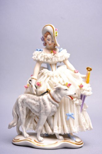 K.P. Muller, Lacy Figurine of Woman w/Dog, 7 1/2": Lacy figurine of a woman wearing an elaborate lacy gown and flower encrusted hat. She is walking a dog and carrying a parasol, marked "K.P. Muller" and "Made in Germany." She stands 7 1/2" high. Condi