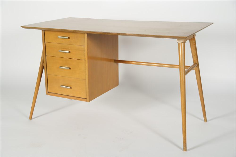 Style of Paul McCobb, Blonde Wood Desk: Blonde wood. Desk: Height: 28 3/4", Length: 48", Depth: 24". Blonde wood desk in the style of Paul McCobb. Tapered legs. Two deep drawers with metal pulls. Appears unlabeled.