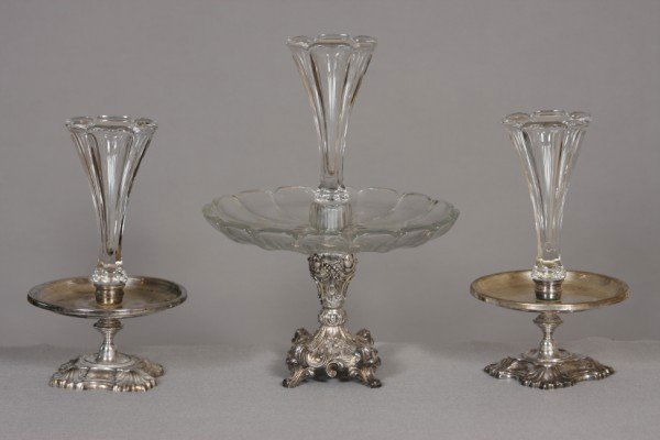 Crystal and Silver Plated Epergne Garniture, Ameri: Comprising center epergne with paneled trumpet vase and panel tray raised on a silver plated c-scroll and acanthus base. Together with 2 small similar epergnes. Larger H: 15" Pair Smaller H: 11 1/2".