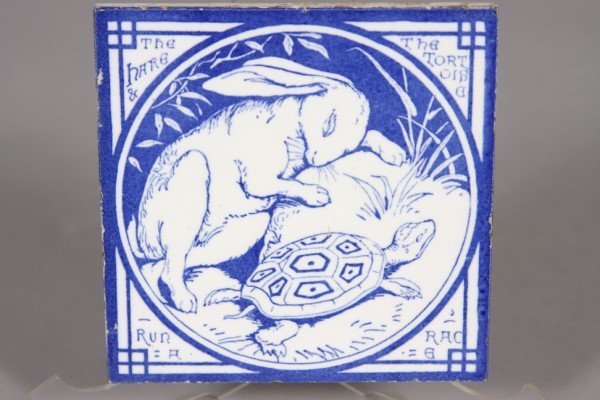 Minton Tile; The Hare and the Tortious Run a Race: 6" x 6". Depicting Aesop's's fable image. Condition: Good with minor wear at edges.