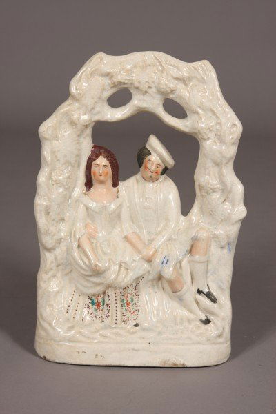 Staffordshire Pottery Figural Arbor Group, English: Depicting a courting couple beneath an arbor. Dimensions: H: 14" W: 9" Condition: Glaze Is Cracked Overall, Glaze Is Worn Off 1" Place On Front Of The Base. Bottom Slightly Uneven.