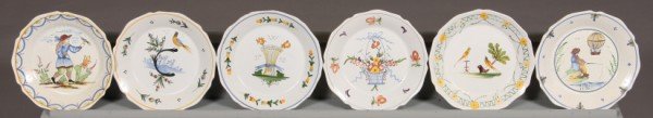 Group of Six Faience Cabinet Plates, French, 20th: Two decorated with figures and Four (4) with floral and bird motif. Diameter: 9" Condition: Two With Figures Have Cracked Glaze. One With Nick To The Rim.