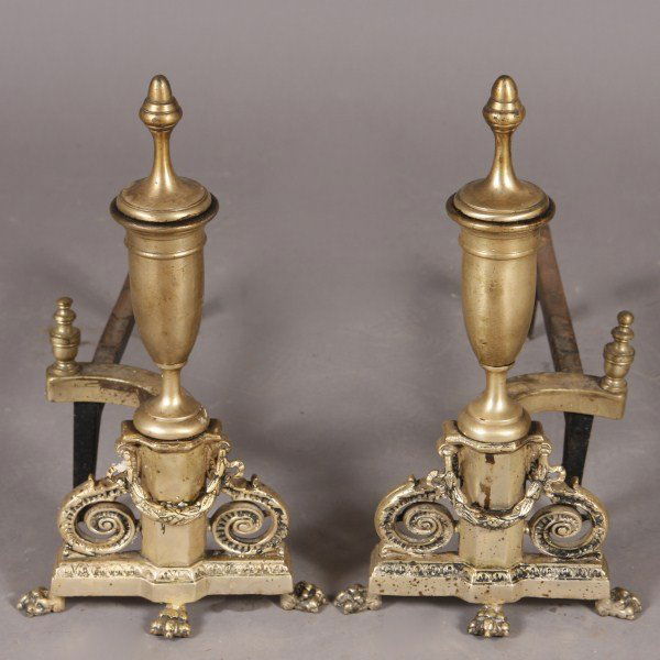 Pair Brass Andirons, American, 20th C. Neo-Classica: American, 20th century. Neo-classical urn on a pedestal base with a laurel and scroll. With remnants of a silver finish. Height: 16" Condition: Silver finish is worn.
