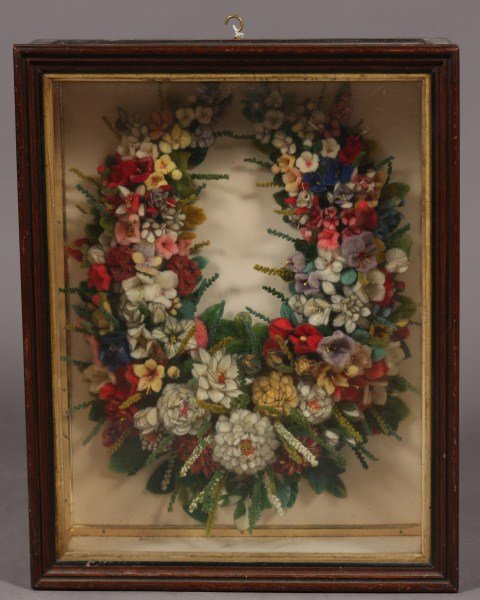 Victorian Wool Work Wreath, American, Early 20th C: American, early 20th century. A floral wreath in a shadow box frame. Dimensions: 17" x 12 1/2" Condition: Interior fabric of the shadow box frame is discolored.