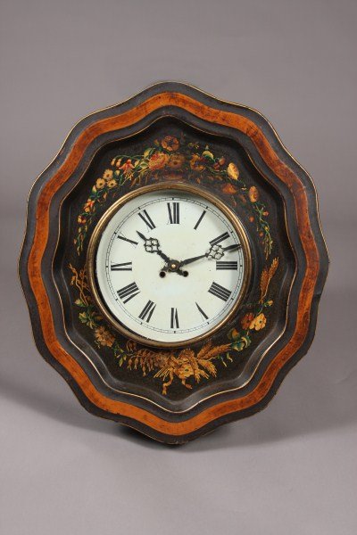 Tole Wall Clock, French, Late 19th Century, Height: French, late 19th century. Shaped oval form painted with trailing floral motif surrounding a Roman numeral dial. Dimensions: H: 19 1/2" W: 23" Condition: The clock dial is missing the glass cover. Min