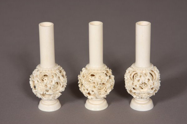 Three Carved Ivory Bud Vases, Chinese, 20th Centur: With cylindrical vase on a carved puzzle ball. H 5 1/2". Condition: Two with cracked foot rims. Please note ivory cannot be shipped out of the U.S.