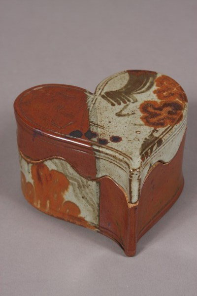 Plum Tree Pottery Heart Form Covered Box, American: 20th century. With paneled brown and grey glaze. Signed by John Glick. Dimensions: H 4 1/4"; W 6 5/8"; D 6 1/8". Condition: Appears fine.