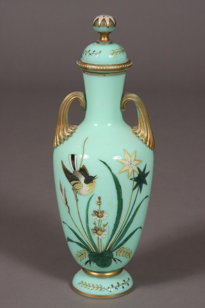 Light Green Opaline & Enameled Covered Vase, Conti: Continental, early 20th century. Baluster form with domed lid and baluster body. Enameled decorated with bird among reeds, gilt highlights. Height: 15". Condition: The gilt is worn.
