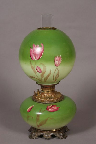 Victorian Blown Glass GWTW Oil Lamp, American, Late: Late 19/ early 20th century. Gone with the wind lamp transfer decorated with tulips. H 20". Condition: The transfer is smudged in several places. Finish on the base is worn off.