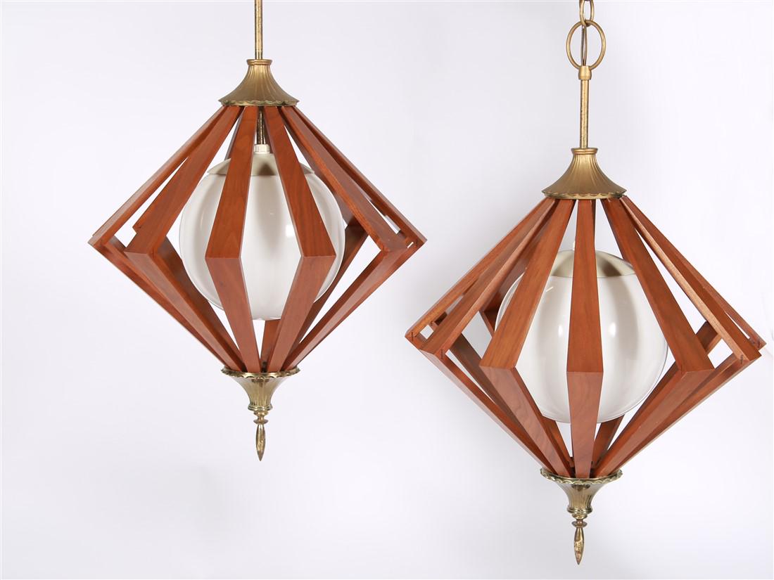 Pair of Teak Diamond Pendant Lamps: Teak, metal. Height: 25", Diameter: 17". Pair of teak hanging pendant lamps / chandeliers with diamond cut-out design. Glass bulbs inside the teak diamond. Brass-toned metal hardware. Untested.