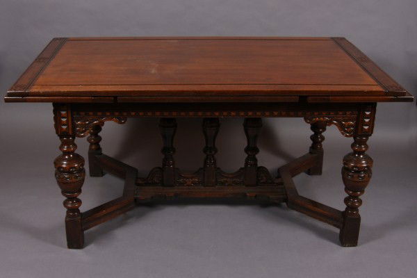 Jacobean Style Oak Dining Table and Six Chairs, Ame: American, early 20th century. The table with rectangular top with pull out end leaves on carved and turned legs. With Four (4) side and Two (2) open arm chairs. Dimensions: Table H 30 1/2"; W 62"; D 3