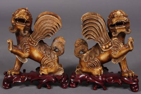 Carved Ivory Winged Foo Dragons, Chinese, 20th C.: Pair carved ivory winged foo dragons. Chinese, 20th Century. H: 5" without stand. Condition: Several feathers on one wing are chipped on the points. Please note: Ivory cannot be shipped outside the Un
