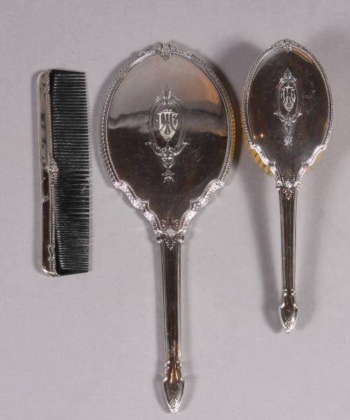 Sterling Silver 3 Piece Dresser Set, 20th C.: Sterling silver three piece dresser set. American, 20th Century. Including a hand mirror, brush, and comb. Monogrammed. Mirror L: 13 1/2". Condition: The brush is discolored and chipped. The surface o