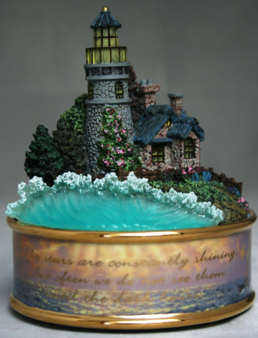 Thomas Kinkade "New Day Dawning" Heirloom Porcelai: Thomas Kinkade "Seaside Illuminations" Heirloom Porcelain Music Box, No. A0755. From the "Seaside Illuminations" Collection. Plays "You Are the Sunshine of My Life". #21. New without box. Condition: A