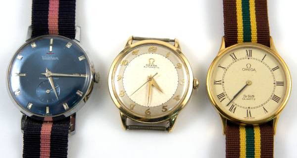 Three Vintage Watches, Two Omega & One Waltham: Lot of three vintage watches. One Omega "Omega Automatic", 14K gold filled, diameter 1 4/". One Omega Deville, quartz movement, diameter 1 1/4", on blue and pink grosgrain band. One Waltham manual win