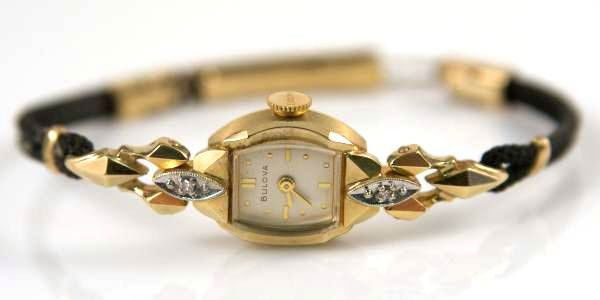 Ladies Bulova 14K Yellow Gold Watch Set W/ Two Diamonds: Ladies Bulova watch made of 14k yellow gold set with two diamonds. In original Bulova box. Marked "14K Gold", "L2", "1614679" on back, "Bulova" on face and winding mechanism.
