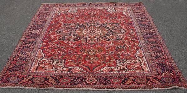 Heriz Rug, Red & Brown, Iranian, 20th Century: Heriz rug. Iranian, 20th century. With red and brown central medallion, against a foliate ground within foliate border. 10' 4" x 7' 8". Condition: Appears fine.