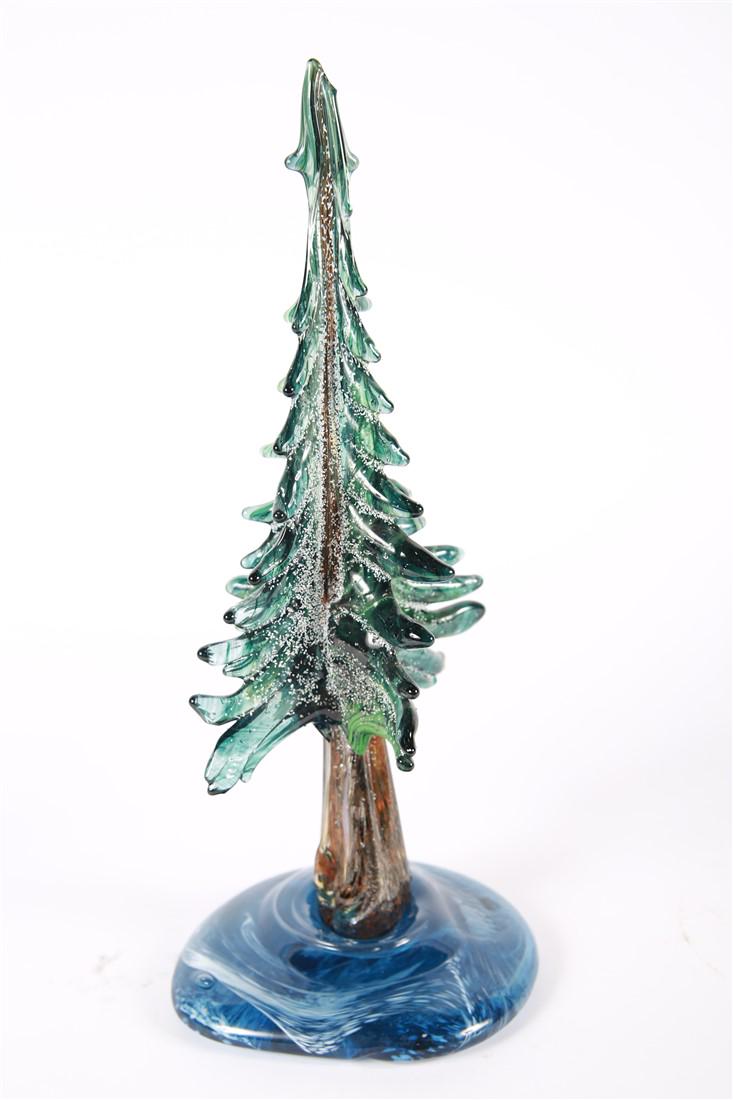 Art Glass Christmas Tree with Snow: Glass, 2013. Height: 16", Length: 7", Depth: 6 1/4". Blue and white swirled base. Green glass foliage applied vertically to the trunk.