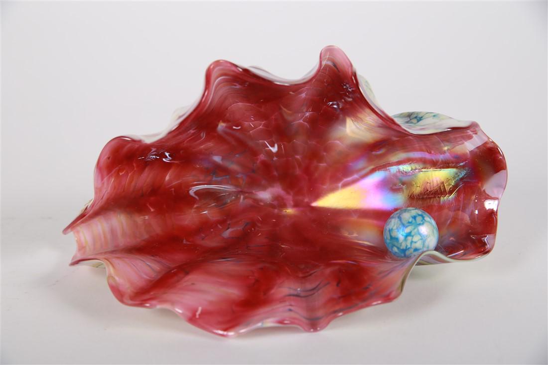 JB, Pink-Multicolor Art Glass Clam: Signed, "JB". Glass. Height: 5", Length: 9", Depth: 5". Form of clam with an iridescent blue pearl inside. Signature on the outside of clam, very small and subtly placed within pattern.