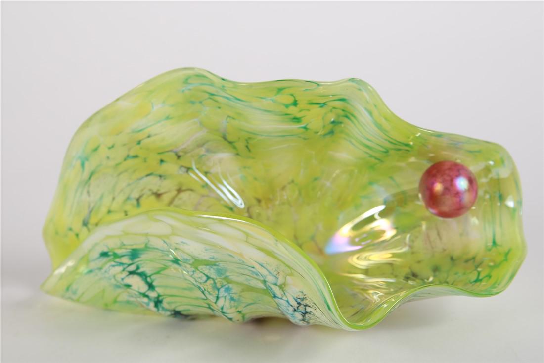 JB, Yellow-Green Art Glass Clam and Pearl: Signed, "JB". Glass. Height: 5 1/4", Length: 10", Depth: 4 1/2". Form of clam with an iridescent pink pearl inside. Signature on the outside of clam, very small and subtly placed within pattern.