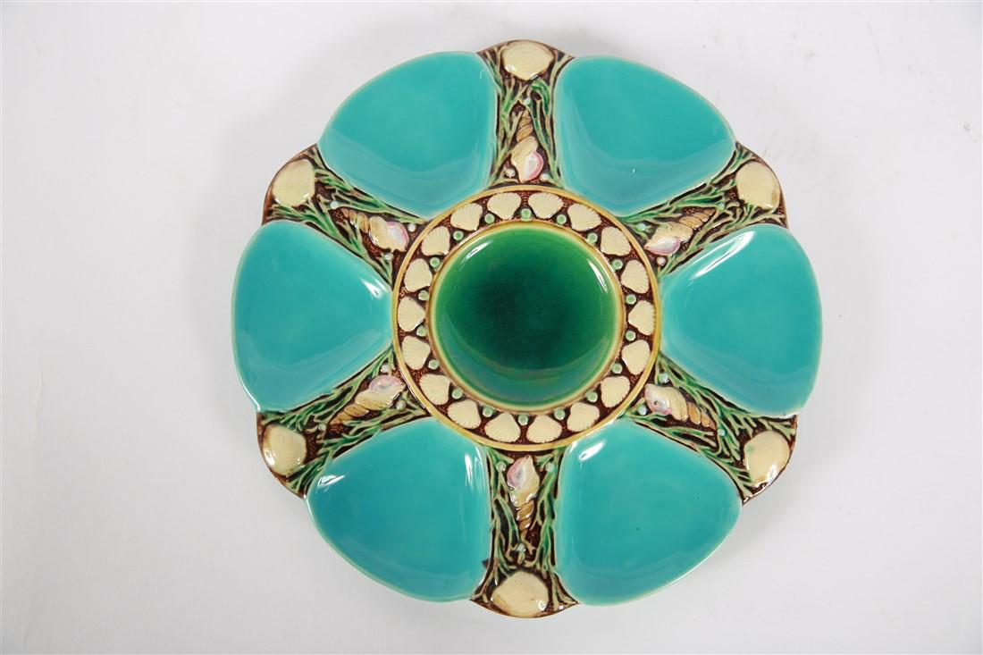 Minton Majolica, Aqua Oyster Plate: Minton Majolica (British, 1793-1968). Glazed ceramic, c. 1870. Diameter: 9". Six turquoise colored wells surrounding a green circular well, outlined with an oyster and seashell motif. Stamped and numb