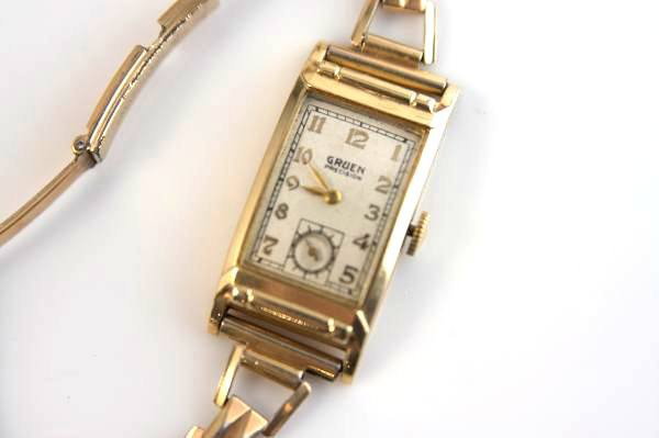 Men's 14K Yellow Gold Gruen Watch: Men's 14k yellow gold watch with 12k gold filled band. Made by Gruen. Watch face length 1 1/8", width 3/4". Engraved "Presented to Jim Wilson By His Associates Fisher Body Cleveland Division January 1