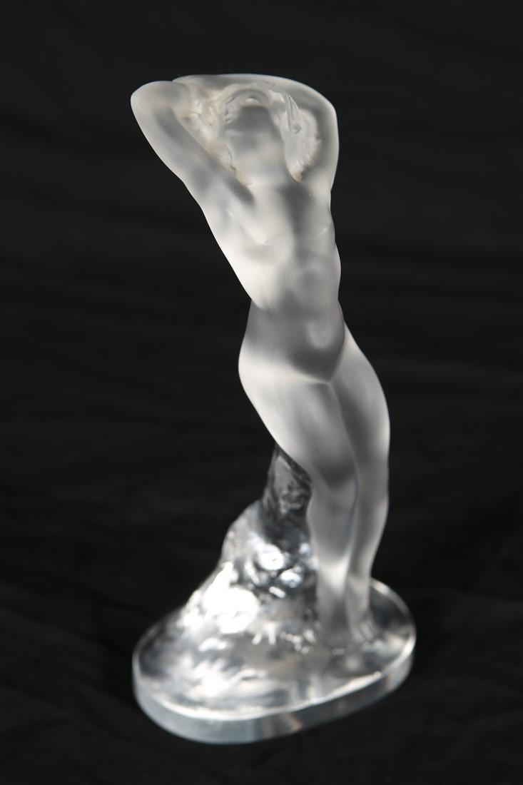 Lalique, "Danseuse Bras Leves" Crystal Figure: Lalique (French, established 1888). "Danseuse Bras Leves" figure. Frosted crystal. c. mid-20th century. Height: 9 3/8", Length: 4 1/2", Depth: 2 3/4". Lalique crystal figurine depicting a nude female 