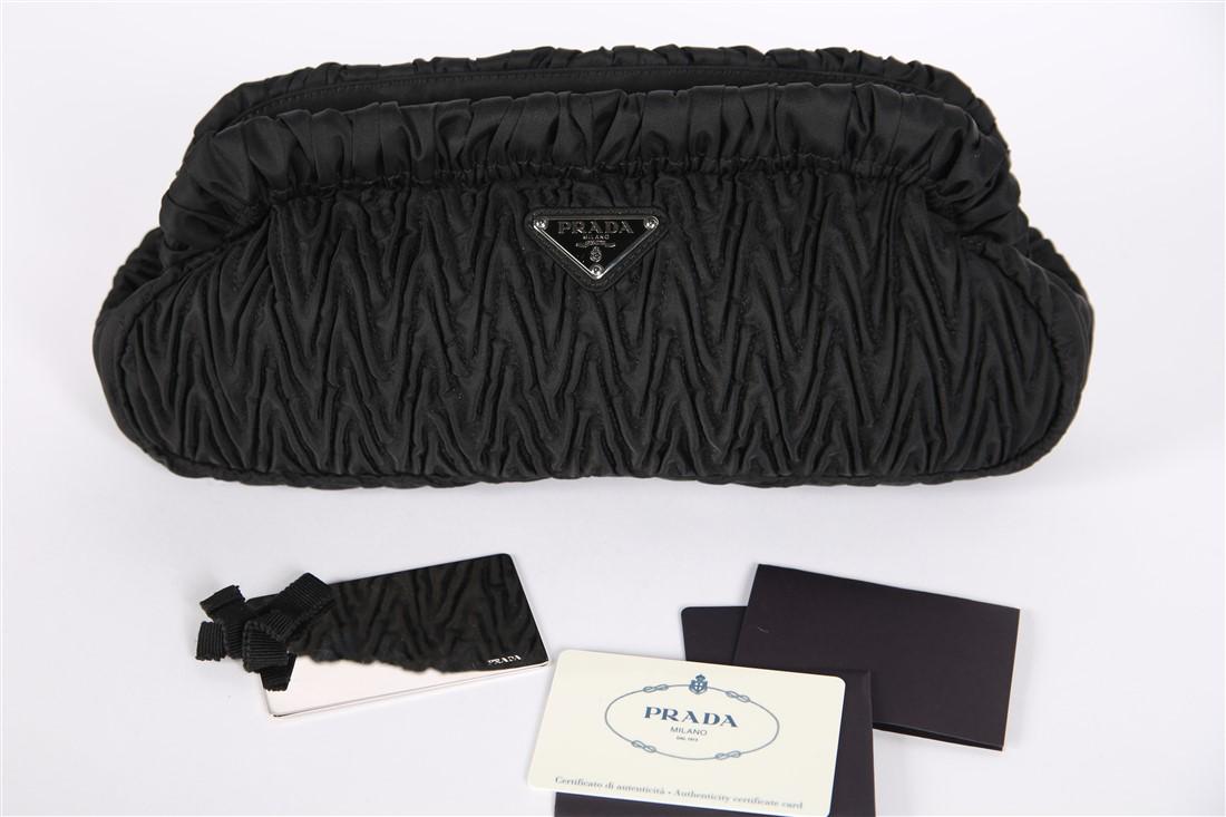 Prada, Tessuto Chevron Pochette Ruched Bag: Prada (Italian, est. 1913). Tessuto Chevron Pochette bag. Nylon, metal. Height: 5", Length: 12", Depth: 3 1/2". Black (nero) ruched nylon evening bag. Includes metal business card-sized mirror, certif