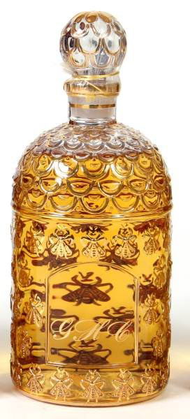 Guerlain Gilt Glass "Nahema" 34 Oz. Perfume: An oversize bottle of Guerlain "Nahema" eau de toilette. Made by Guerlain, Paris, France, 20th century. The bottle having a bee pattern and decorated in gold gilt. 34 ounces. Height 10 1/4", diameter
