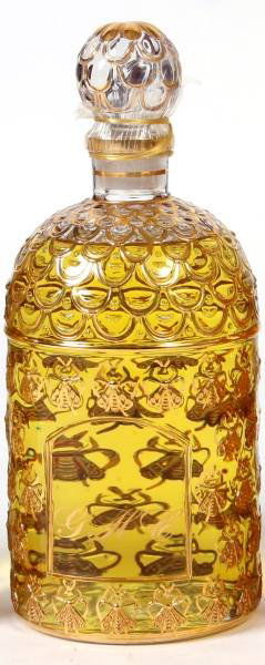 Guerlain Gilt "Chant D'Aromes" 34 Oz. Perfume: An oversize bottle of Guerlain "Chant D'Aromes" eau de toilette. Made by Guerlain, Paris, France, 20th century. The bottle having a bee pattern and decorated in gold gilt. Numbered "025750" underfoot.