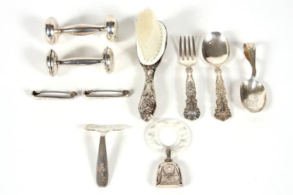 Collection of Sterling Silver Baby Items, 4 Ozt.: Collection of sterling silver baby items. 20th century. Including bar bell rattles, Tiffany food pusher, feeding spoon, Gorham child's fork and spoon, ring rattle, hair brush and silver plated diaper 