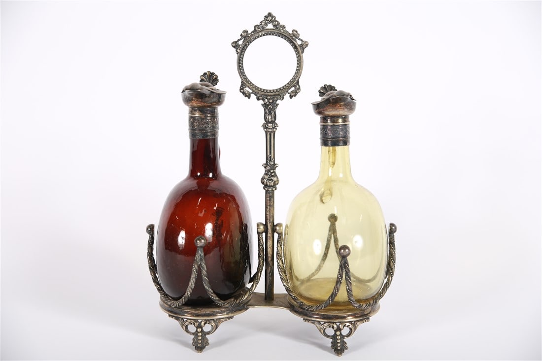 John Sherwood and Sons, Silver Plated Oil Caddy: John Sherwood and Sons (England, 1858-1913). Silver plate, glass. Height: 12 1/2", Length: 10", Depth: 6 1/2". Silver plated oil caddy. Two glass jars, one amber colored and one yellow colored. Marked