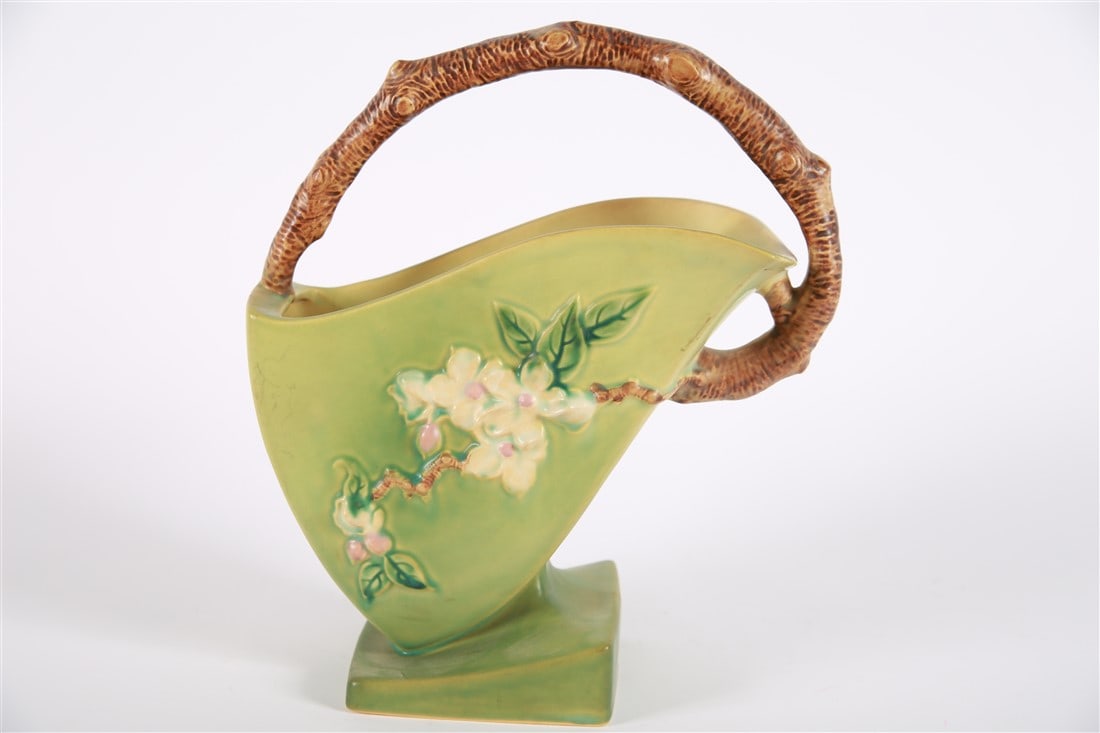 Roseville, Apple Blossom Angular Basket: Roseville Pottery (American, 1890-2017) Ceramic. Height: 12 3/4", Length: 11", Depth: 5". Green ground with white flowers that have pink centers. Brown branch-shaped handle and detail behind petals. "