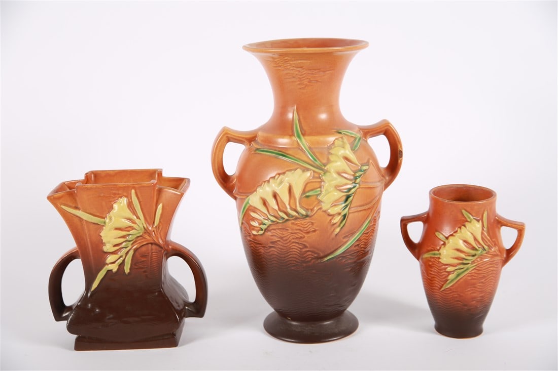 Roseville, Tangerine Freesia Vase Collection: Roseville Pottery (American, 1890-2017). Ceramic, 1945. Largest: Height: 12 5/8", Length: 8 1/4", Depth: 6 1/2". Smallest: Height: 6 3/8", Length: 5 1/4", Depth: 3 1/2". White and green floral detail 