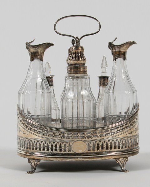 George III Silver Cruet Stand: George III silver cruet stand. London, first quarter 19th century. With wriggle work decoration. Fitted with six crystal bottles having silver mounts. Height 9 1/2", width 7 1/8".