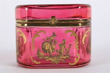 Cranberry Glass Gilt Vanity Casket: Glass. Height: 4 1/4", Length: 5 1/2", Depth: 3 3/4". Cranberry glass box with ormolu hardware and metallic gold hand painted details, including Rococo-style romantic scenes.