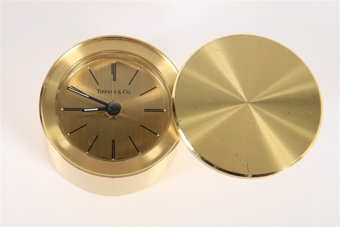 Tiffany and Co., Brass Travel Clock: Tiffany and Company (American, established 1837). Brass, glass. Height: 1 1/2", Diameter: 2 3/8". Tiffany and Co. travel clock. Glow in the dark hands. Serial no. 200570. Untested.