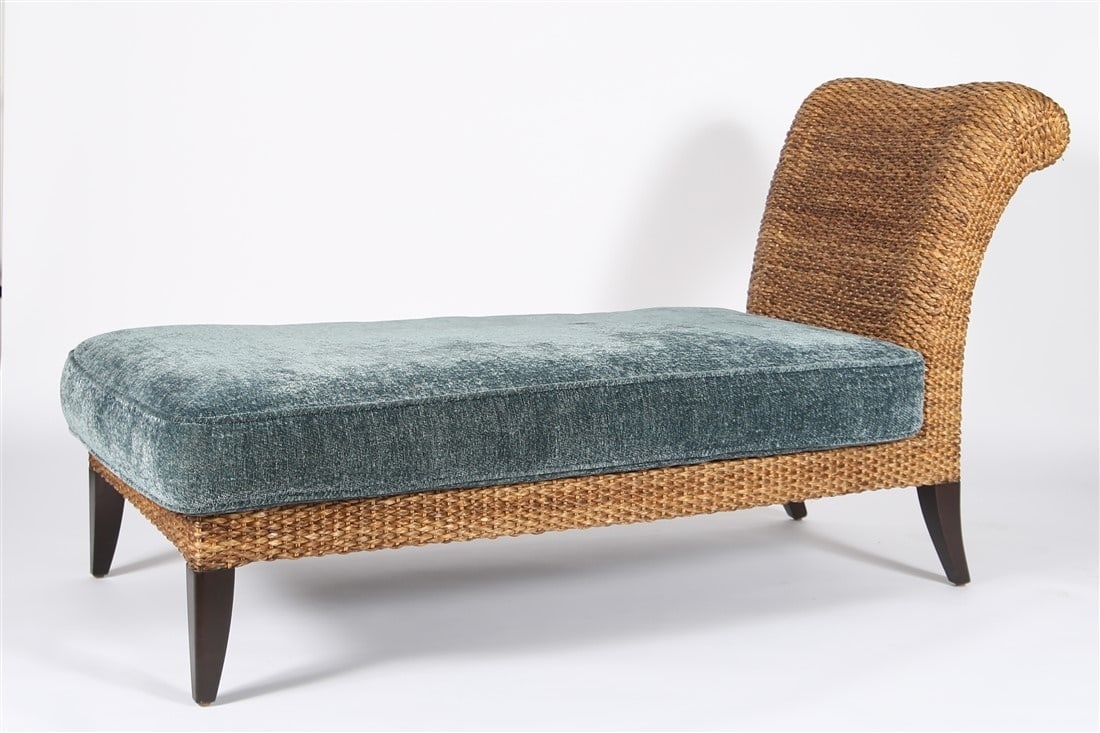 Wicker Chaise Lounge: Wicker, upholstery. Height: 37 1/2", Length: 67 1/2", Depth: 29". Contemporary wicker framed chaise lounge with blue cushion on wood feet. Label from "Barbara Taylor" to the underside.