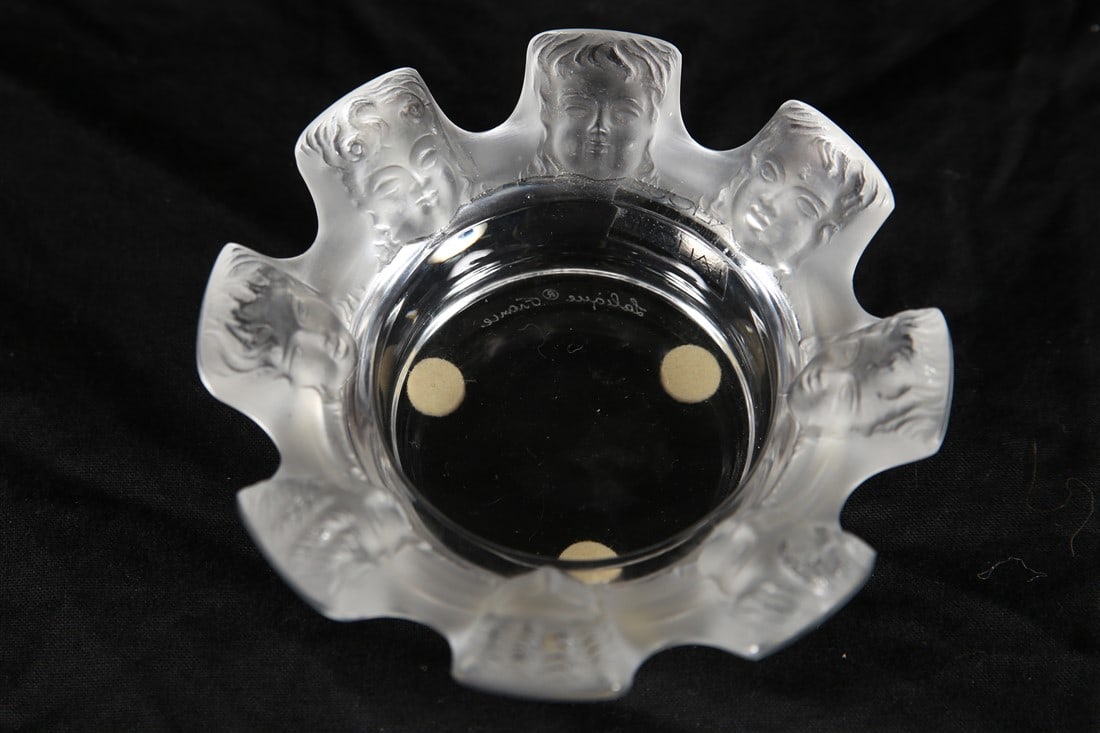 Lalique, "Saint Nicholas" Frosted Crystal Ashtray: Lalique (French, established 1888). "Saint Nicholas" ashtray. Frosted crystal. Height: 1 5/8", Diameter: 4 3/8". Frosted crystal ashtray or trinket dish with cherub faces. Lalique sticker to the side,
