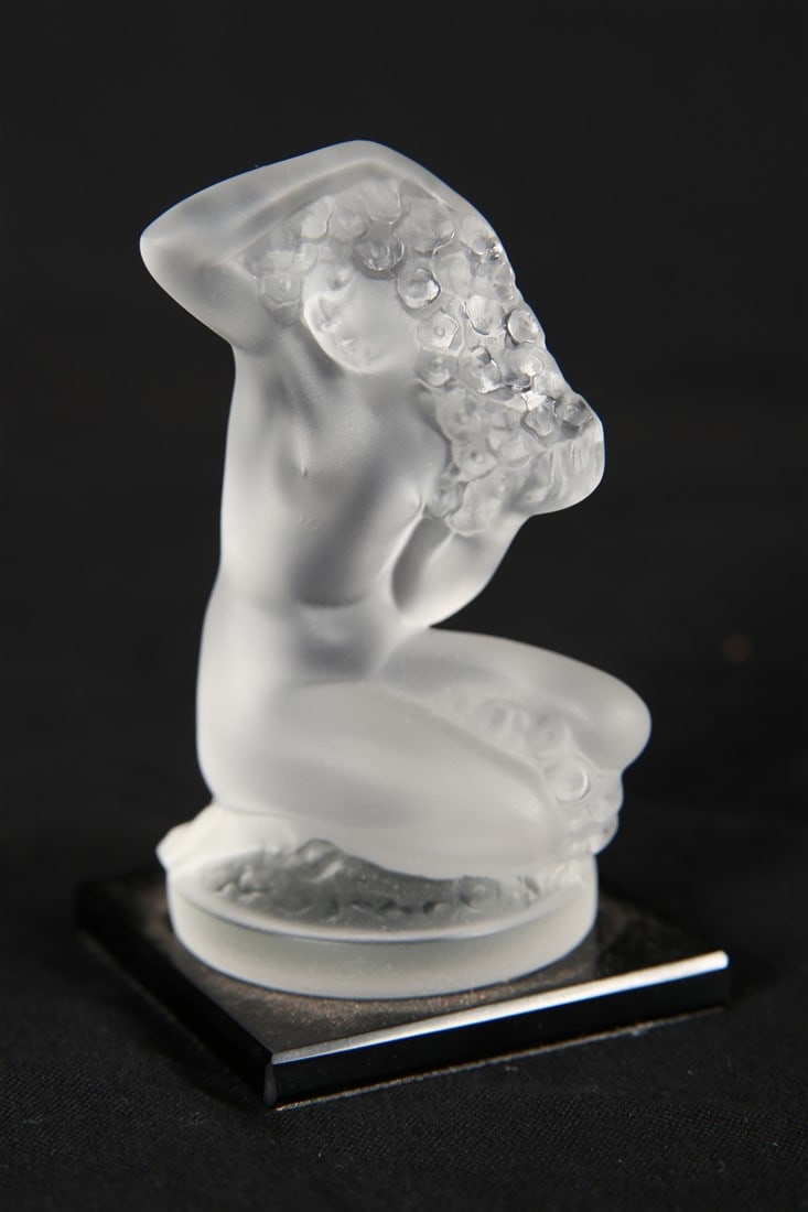 Lalique, "Floreal" Frosted Crystal Figurine: Lalique (French, established 1888). "Floreal" figurine. Frosted crystal. Height: 3 1/4", Length: 2", Depth: 2". Frosted crystal "Floreal" figurine of a crouched woman holding florals in her arms. On a