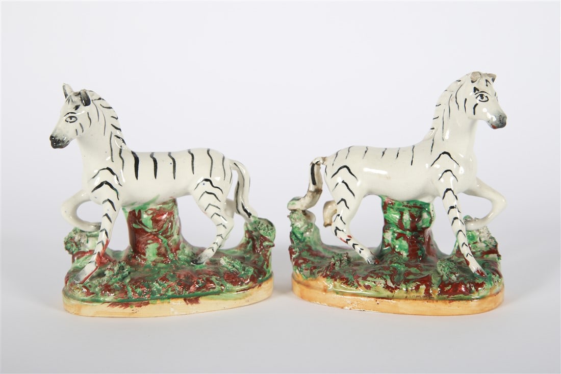Pair of Staffordshire Type Zebra Figurines: Porcelain. Height: 4 3/4", Length: 5 1/2", Depth: 2 1/4". Pair of Staffordshire type standing zebra figurines. Unmarked.